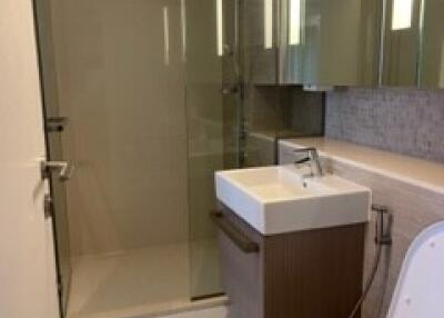 Modern bathroom interior with glass shower, vanity, and toilet