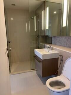 Modern bathroom interior with glass shower, vanity, and toilet