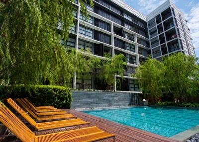 Modern residential building with outdoor swimming pool and lounge chairs