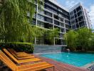 Modern residential building with outdoor swimming pool and lounge chairs