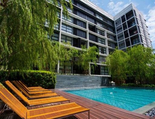 Modern residential building with outdoor swimming pool and lounge chairs