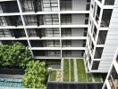 Modern apartment building exterior with balconies and green landscaping