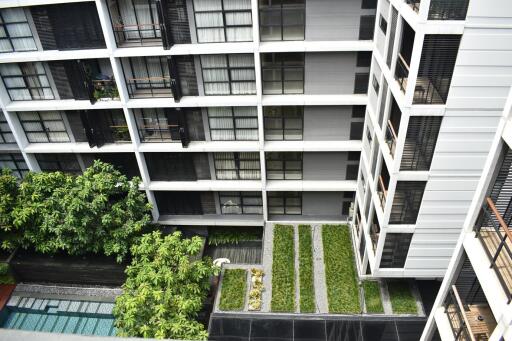 Modern apartment building exterior with balconies and green landscaping