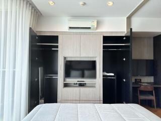 Modern bedroom interior with mounted television and air conditioning unit