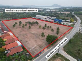 Aerial view of a large plot of land for sale with palm trees and surrounding infrastructure