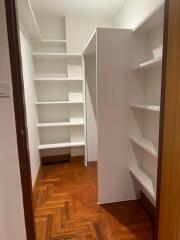 Spacious built-in closet with multiple shelves in a well-lit room
