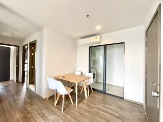 Spacious and well-lit living area with dining table and balcony access