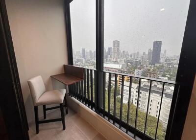 Cozy corner in a high-rise building with a large window showing city views on a rainy day