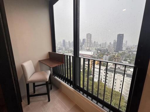 Cozy corner in a high-rise building with a large window showing city views on a rainy day