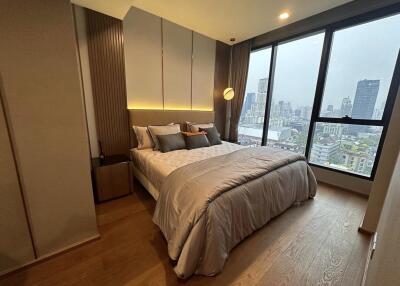 Cozy bedroom with floor-to-ceiling windows offering a city view