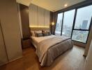 Cozy bedroom with floor-to-ceiling windows offering a city view