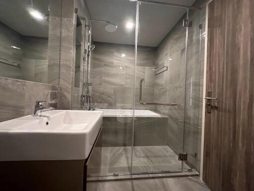 Modern bathroom with glass shower enclosure and grey tiles