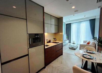 Modern kitchen with integrated appliances leading to an elegant living room