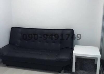 Small living room with a black sofa and white side table