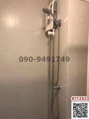 Electric shower unit with hand-held shower head in a tiled bathroom