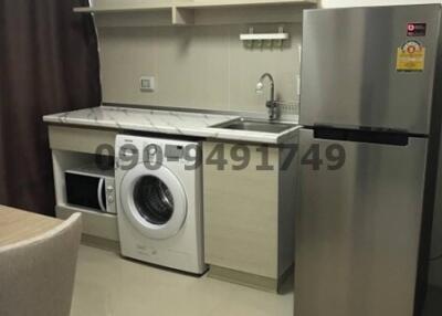 Modern compact kitchen with stainless steel appliances and washing machine