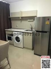 Modern compact kitchen with stainless steel appliances and washing machine