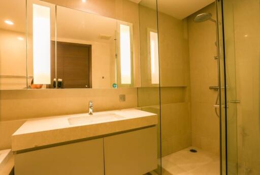 Modern bathroom interior with well-lit vanity area and glass shower