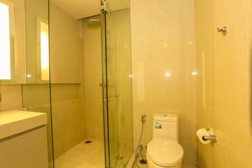 Modern bathroom with shower cubicle and beige tiles