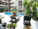 Tropical resort-style pool area with sun loungers and lush greenery