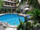 Residential building with a central swimming pool surrounded by greenery and lounge area