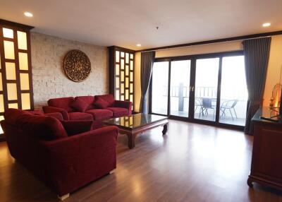 Spacious living room with large windows and red sofas