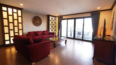 Spacious living room with large windows and red sofas