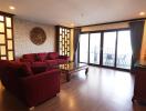 Spacious living room with large windows and red sofas