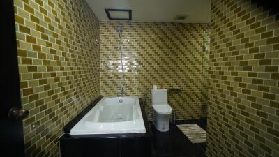 Modern bathroom with golden mosaic tiles and black fixtures