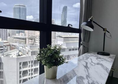 Home office with city view, desk lamp, and plant on a marble top desk
