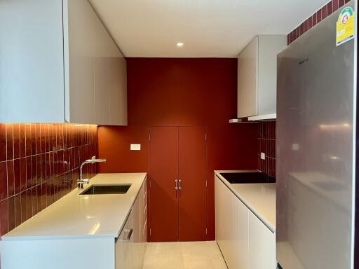 Modern kitchen with red backsplash and white countertops