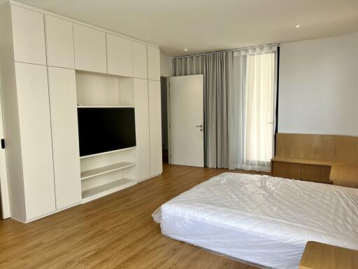 Spacious bedroom with modern built-in wardrobes and hardwood flooring