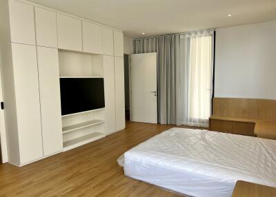 Spacious bedroom with modern built-in wardrobes and hardwood flooring