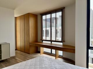 Modern bedroom with large window and built-in wooden wardrobe