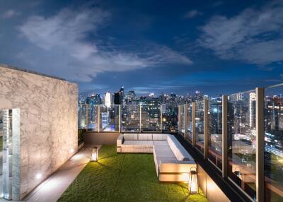 Expansive rooftop balcony overlooking a vibrant cityscape at dusk with comfortable seating and modern design