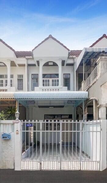 Front view of a two-story residential building with a gated entrance