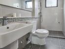 Modern bathroom with tile flooring, wall-mounted sink, and a large mirror