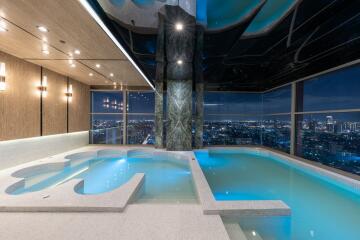 Luxurious penthouse indoor pool with city skyline views at night