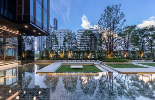 Modern apartment complex with pool and landscaped garden against a city skyline