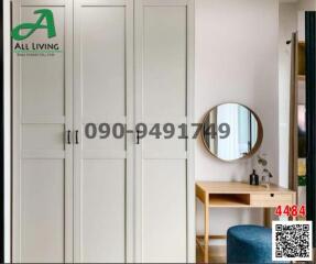 Modern bedroom with a minimalist design, featuring white wardrobe doors and a wooden desk with a circular mirror