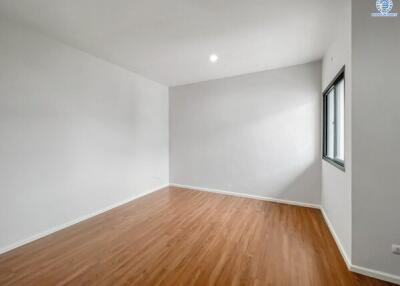 Empty bedroom with hardwood floors and white walls