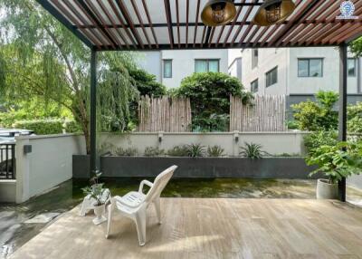 Spacious patio area with greenery and outdoor seating