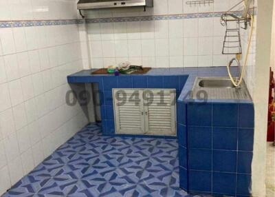 Compact kitchen with tiled walls and blue cabinetry