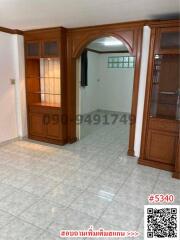 Spacious entryway with tiled floor and wooden arch doorway