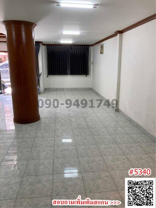 Spacious empty interior space with tiled flooring and large window