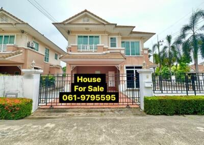 Spacious two-story house for sale with a gate and a clear sky in the background