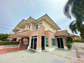 Spacious two-story residential house with a large driveway and tropical landscaping