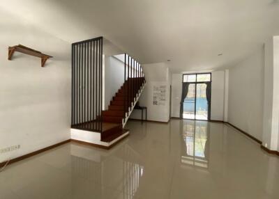 Bright and spacious living area with staircase and glossy floor