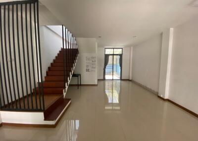 Spacious living room with staircase and bright natural lighting