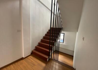Wooden staircase with vertical metal balusters in a well-lit space